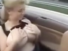 Amateur blonde plays with her huge natural tits in a car