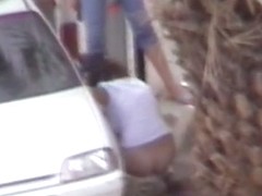 Mature and absolutely hot woman pissing in front of a car